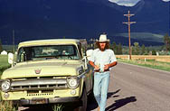 thumbnail link to photograph Steve McQueen by pick up truck mountains behind