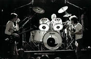 thumbnail link to photograph of The Jam on stage rehearsing, Weller and Foxton drink tea
