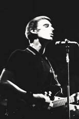 thumbnail link to photograph motion shot of Paul Weller on stage wearing Fred Perry polo shirt